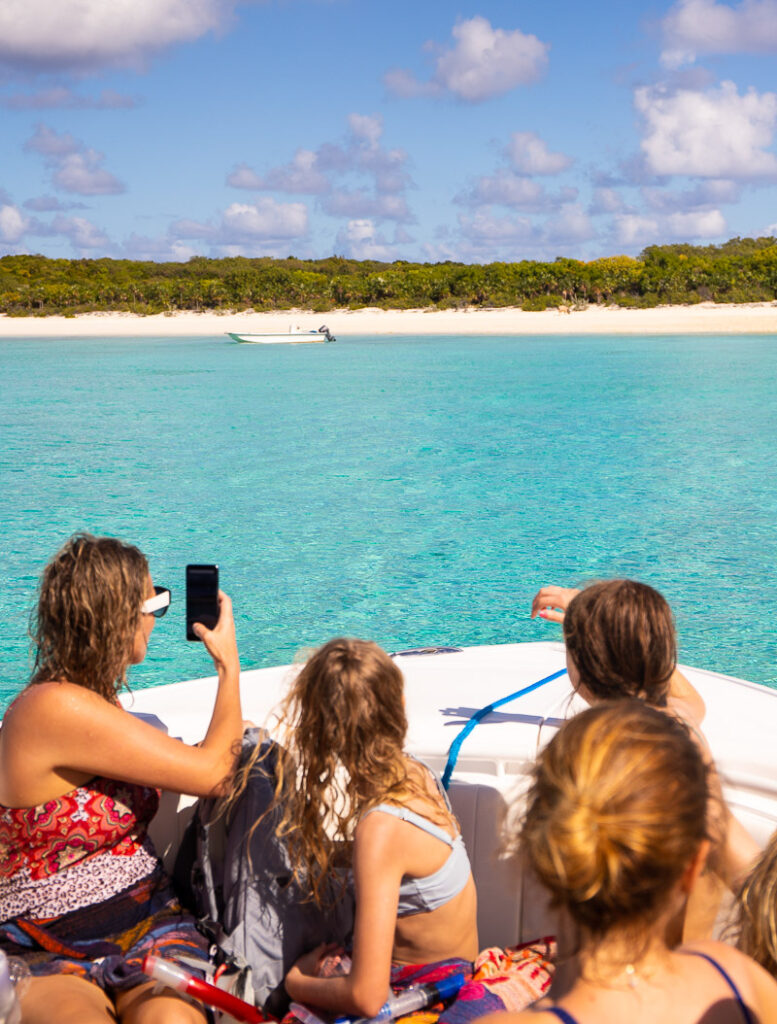 People on a boat in The Bahamas taking a photo of a beach