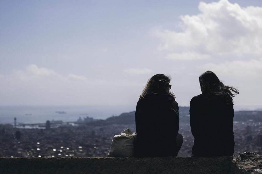 Girls talking and looking at Barcelona cityscape from a viewpoint in Bunkers del Carmel