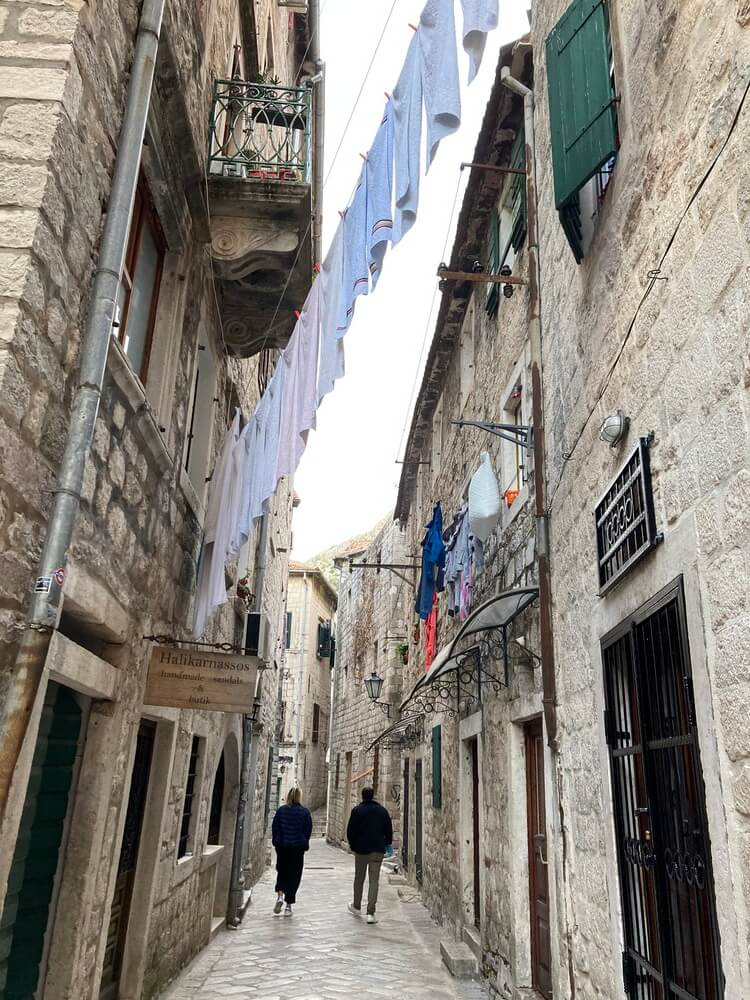 people walking down narrow alleyway