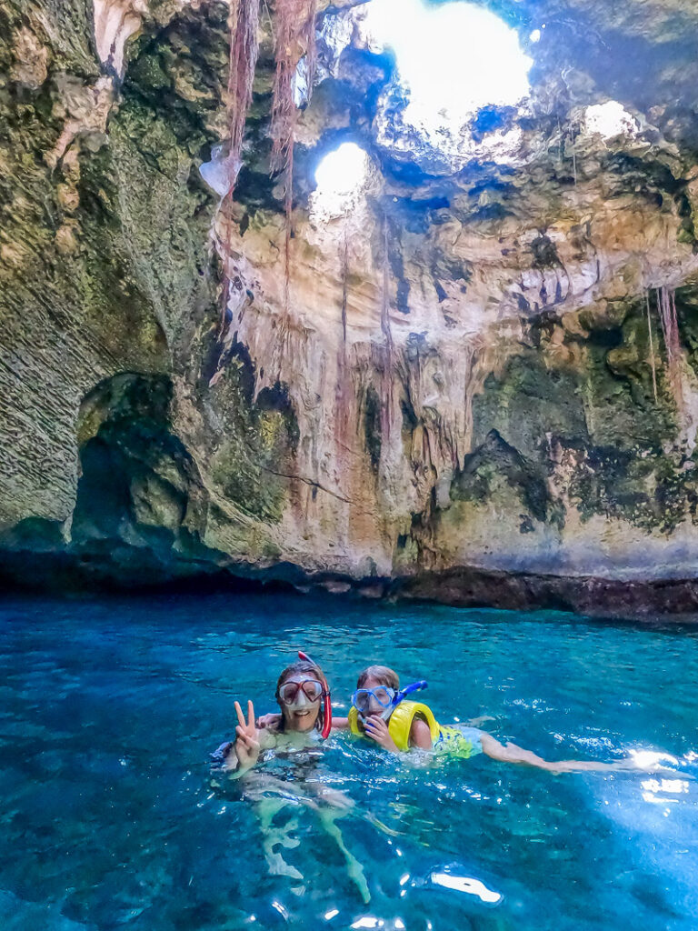 Mom and daughter snorkeling inside a cave