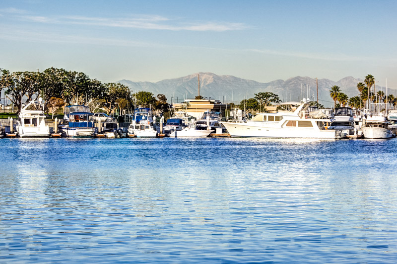 boats in Huntington Harbor with snow capped mt baldy in the distance