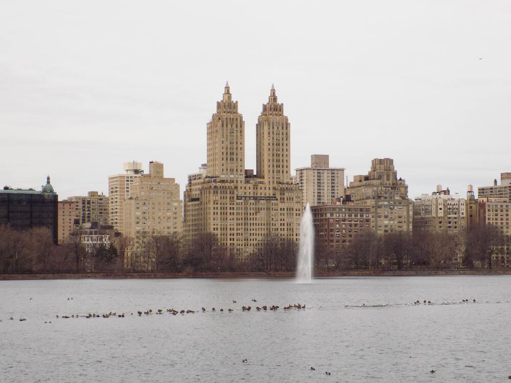 fountain in the lake central park with views of buildings in background