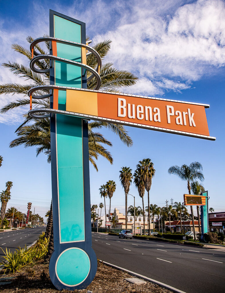 Large street sign saying Buena Park surrounded by palm trees
