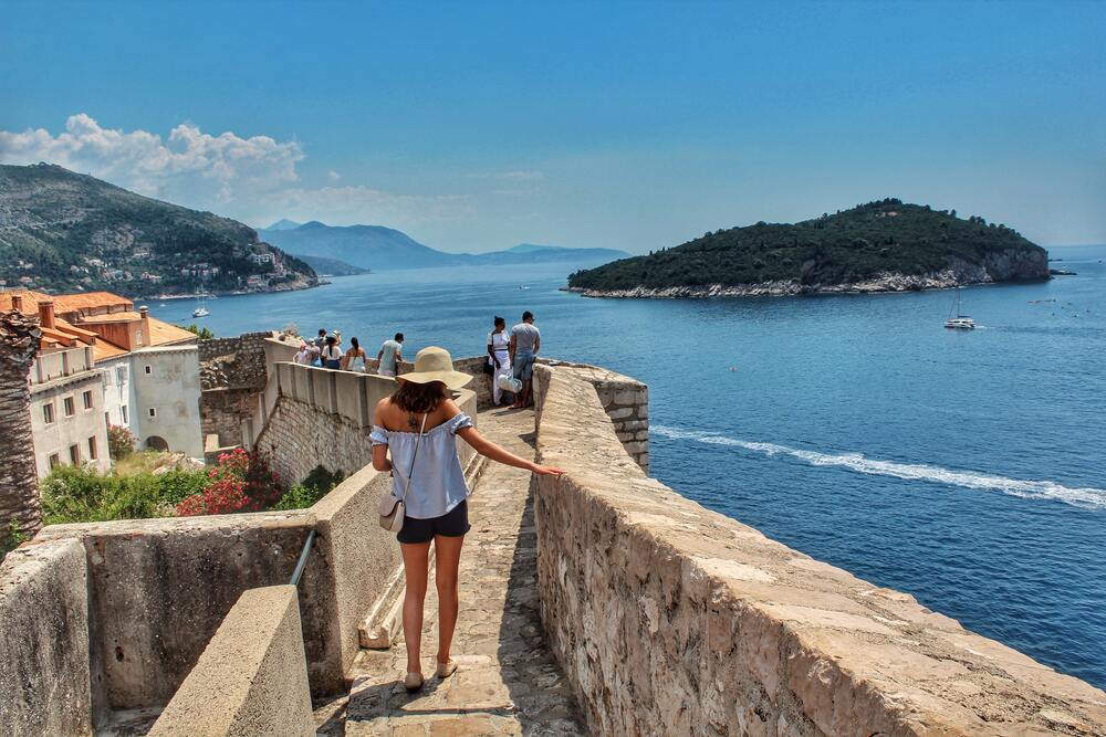 girl walking along the city walls of dubrovnik old town