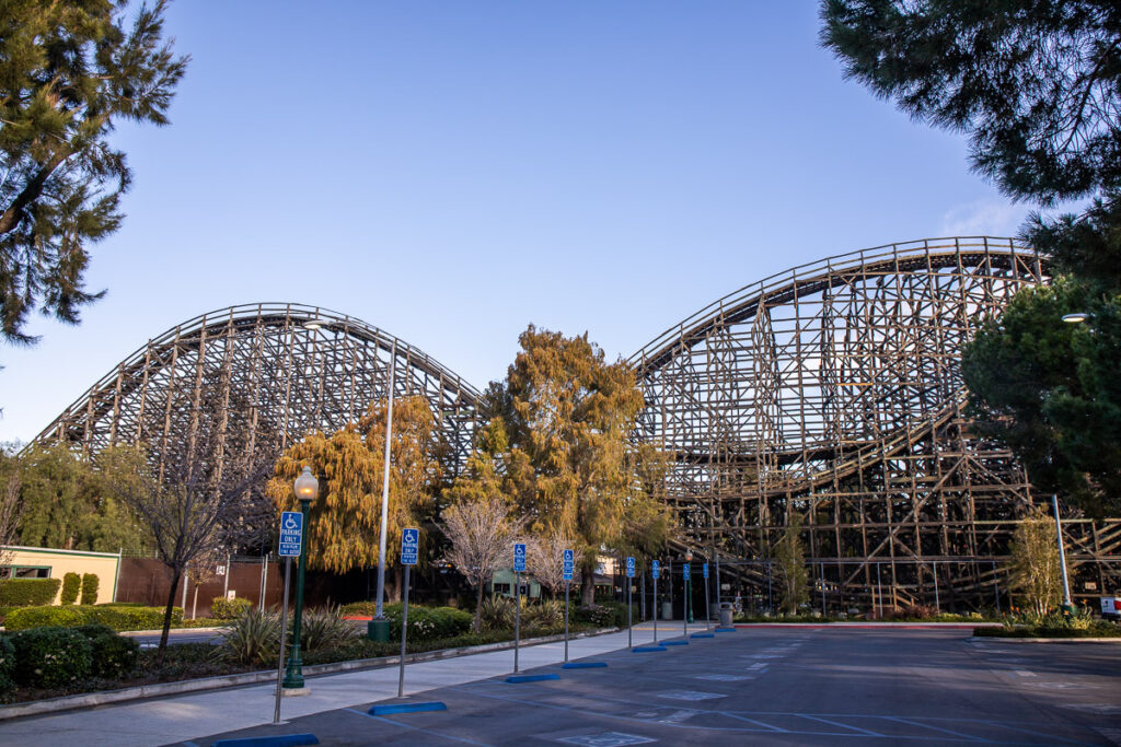 Large wooden rollercoaster surrounded by trees