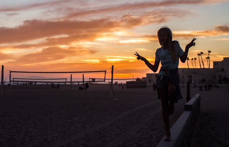silhouette of girl at sunset on Huntington beach near volleyball courts