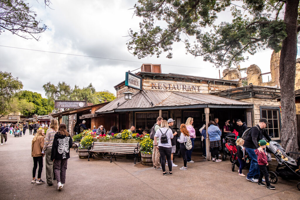 People lined up outside a restaurant inside a theme park