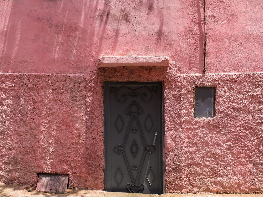 red clay building with wooden door in marrakech
