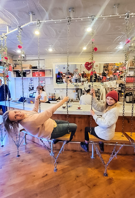 woman and girl sitting on swinging chairs at countermolly cupcakes