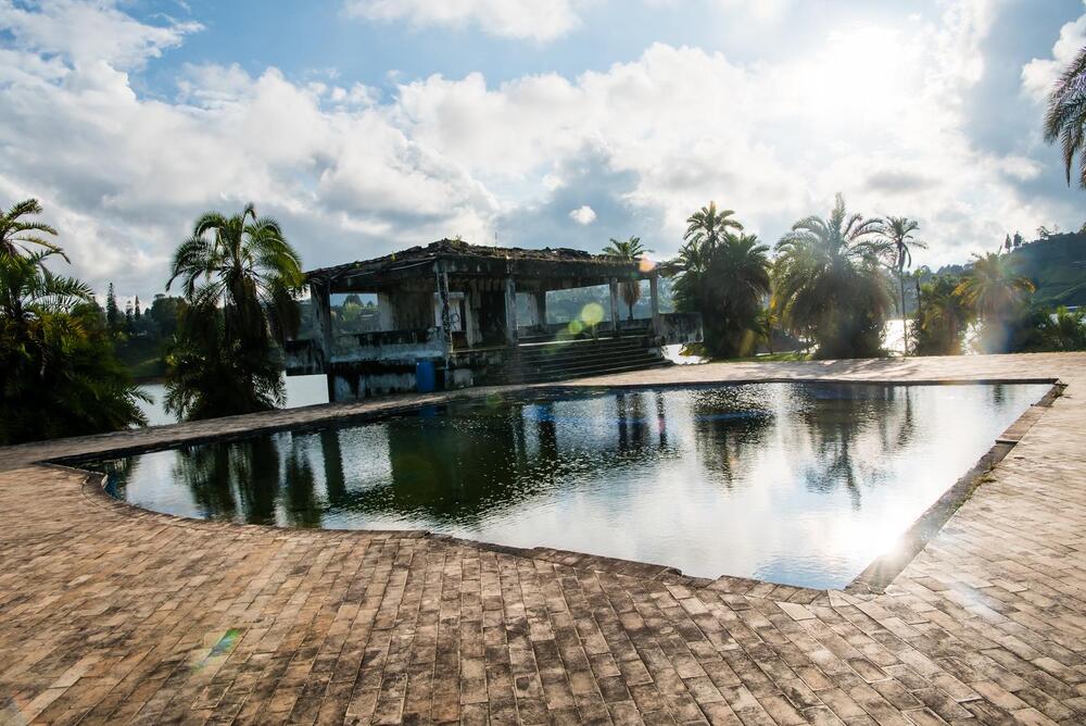 Pablo Escobar's old estate La Manuela in ruin with palm trees and reflection pool