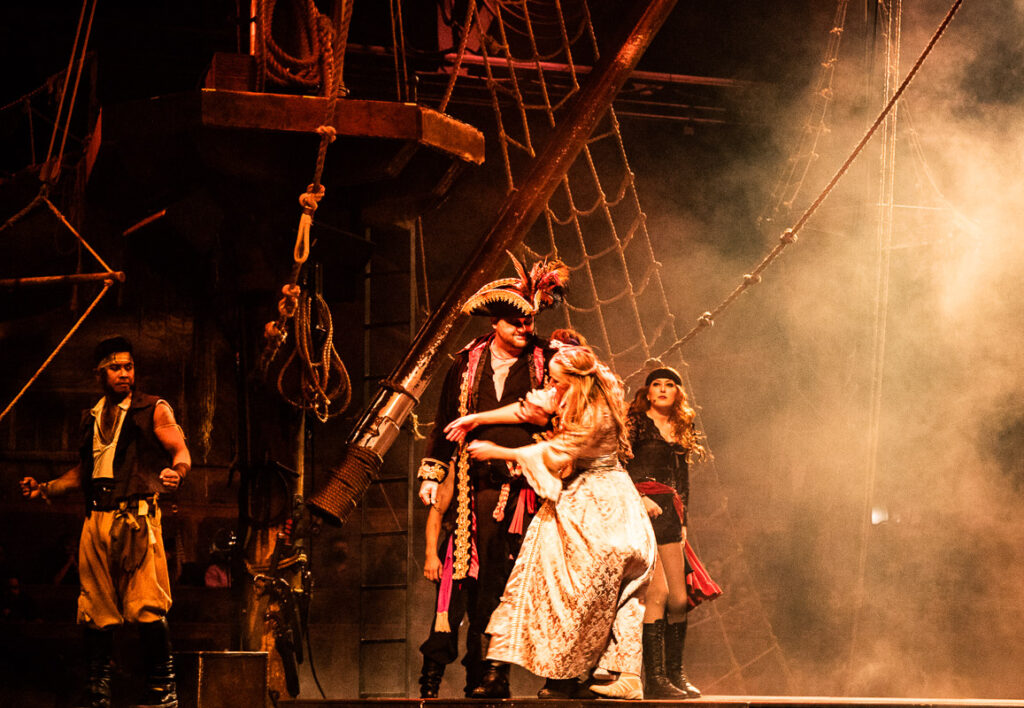 CAst of a pirate show performing on stage
