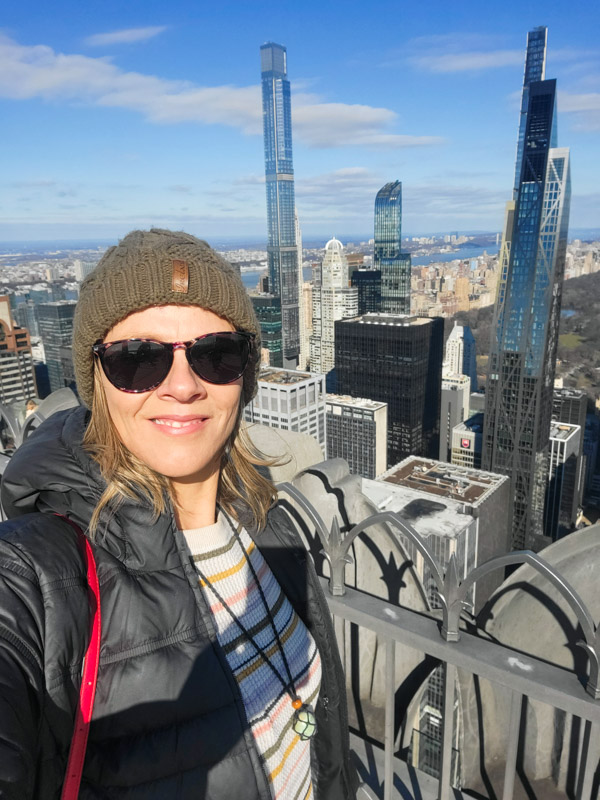 woman taking a selfie on top of the rock with views