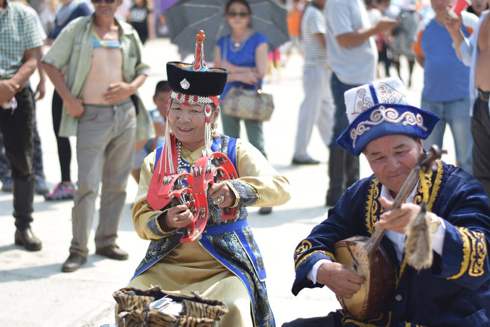 man and wman playing instrucemtns on street at Naadam Festival