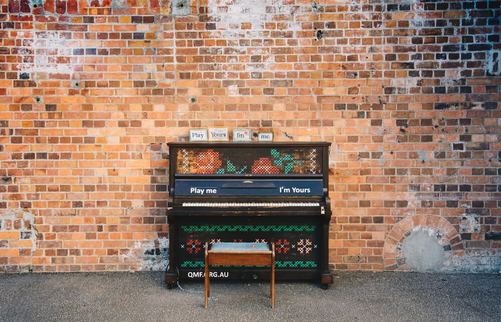 piano against a brick wall