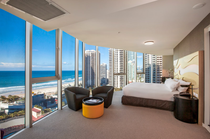 king bed and panaromic ocean views through glass windows