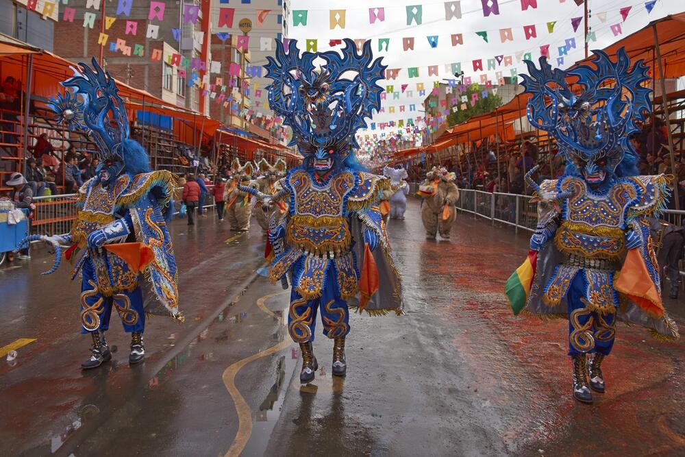 people dressed in elaborate blue costumes at the oruru carnival