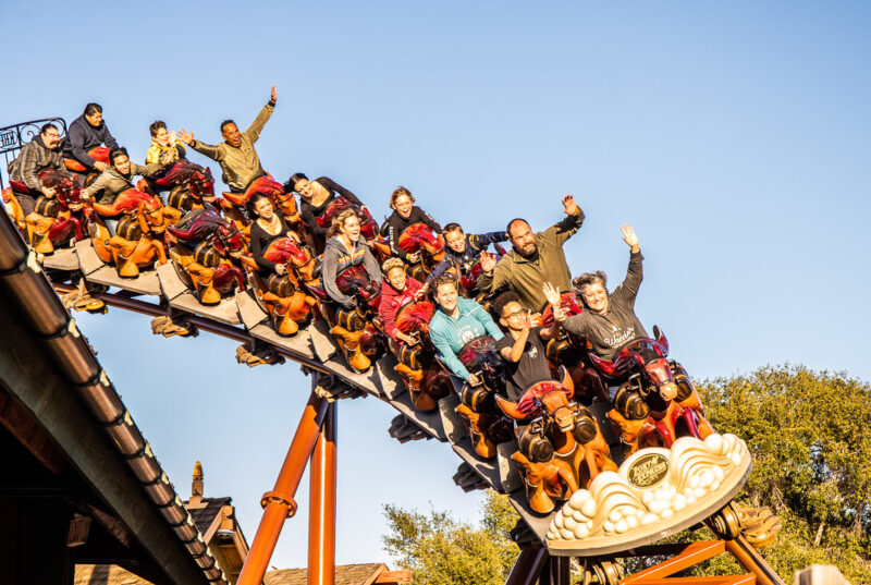 people with hands in the air on the pony express roller coaster