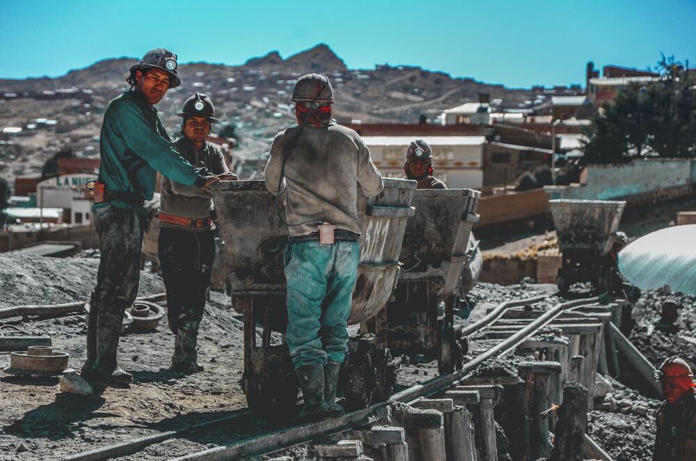 men working beside a mine cart