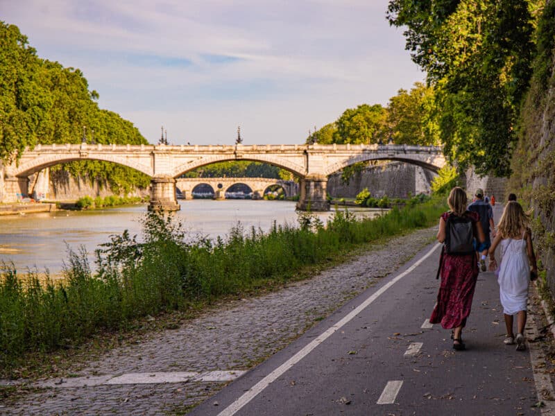 mother and child walking along river tiber pathway rome