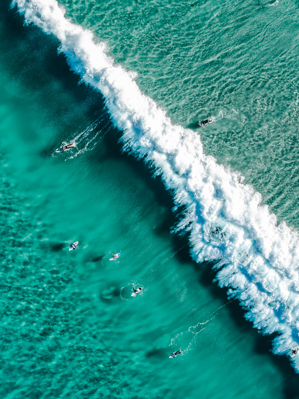 Aerial overlooking surfers catching waves astatine  Tamarama Beach, 