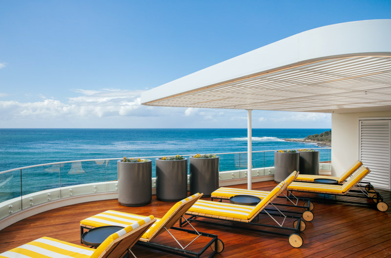 chaise lounge chairs on deck of hotel suite overlooking ocean
