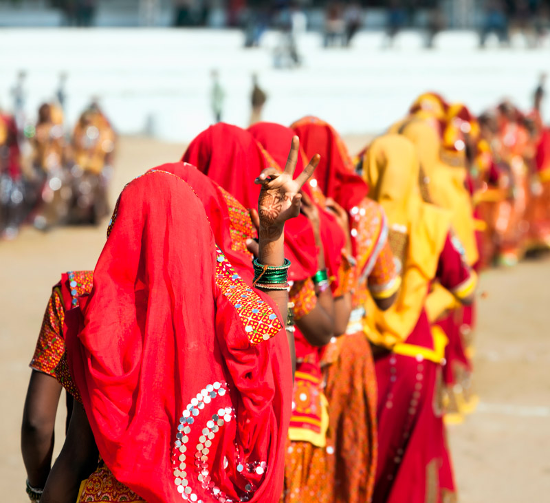 Indian girls in colorful ethnic attire dancing at Pushkar fair, Pushkar, Rajasthan, India, Asia