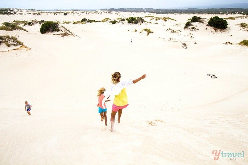 girls racing down sand dunes