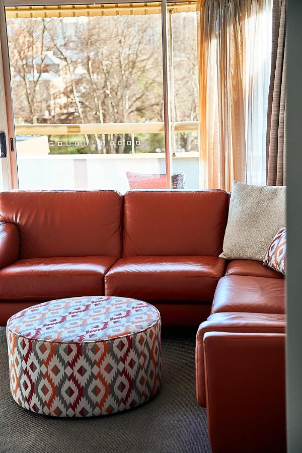 red couch by window in suite 