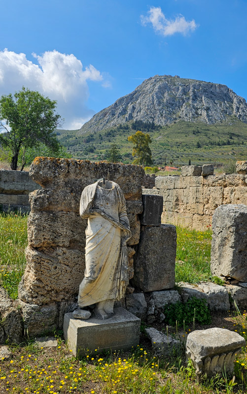 statue amongst ruins with mountain in background