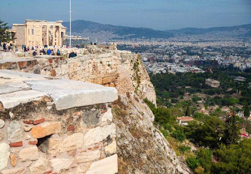 temple building remains on edge of acropolis with views of city and ancient agora below