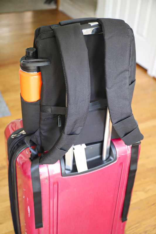 backpack on suitcase with water bottle in pocket