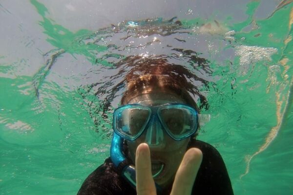 caz giving peace sign to camera underwater