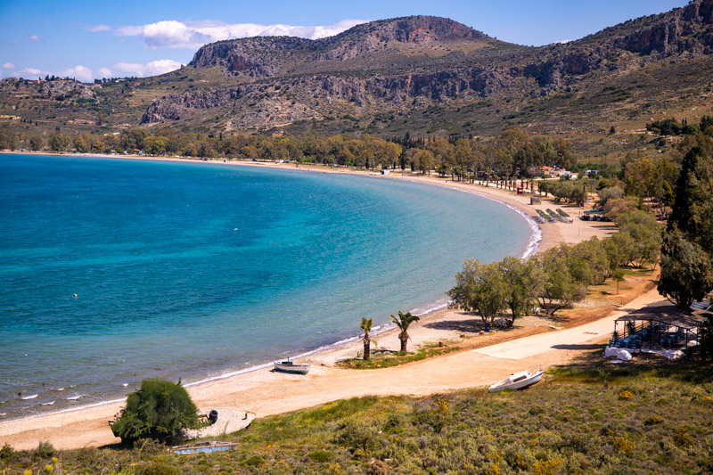 aerial view of curving Karathona Beach with mountains in the background