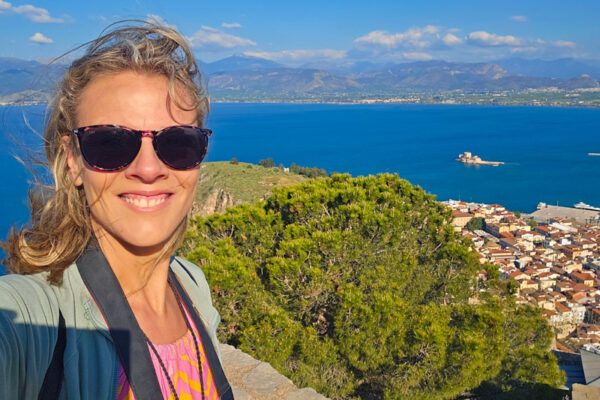 caz smiling at camera with views of nafplio and sea behind her
