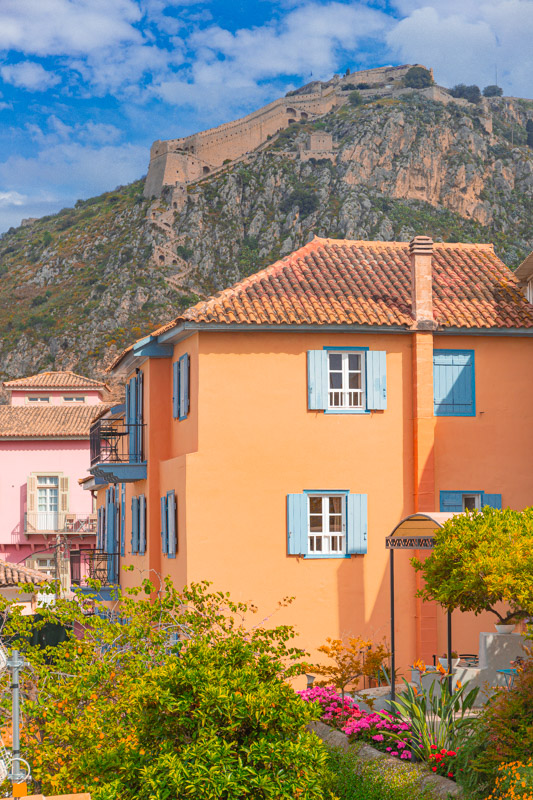 pink and orange buildings in front of Palamidi fortress hill