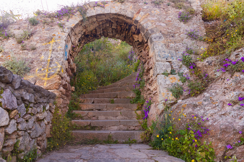 a stone arch over stone stairs
