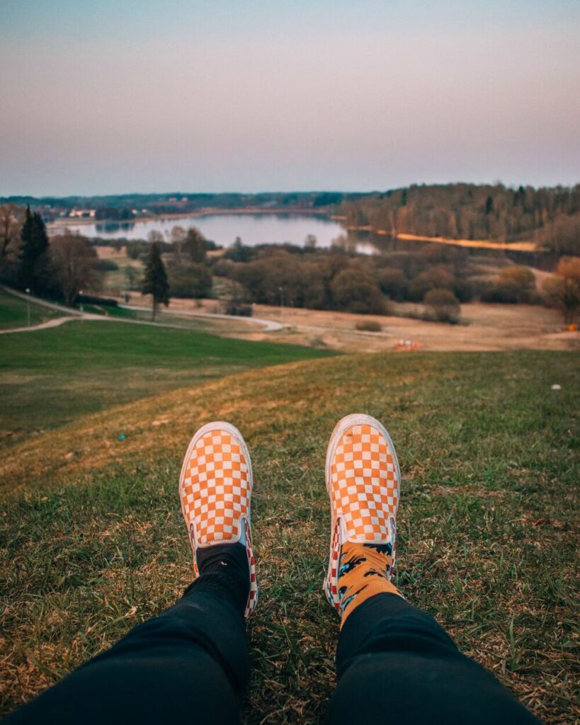 person's feet with the view of lake Viljandi