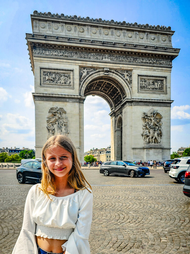 Girl in front of the Arc De Triumph in Paris