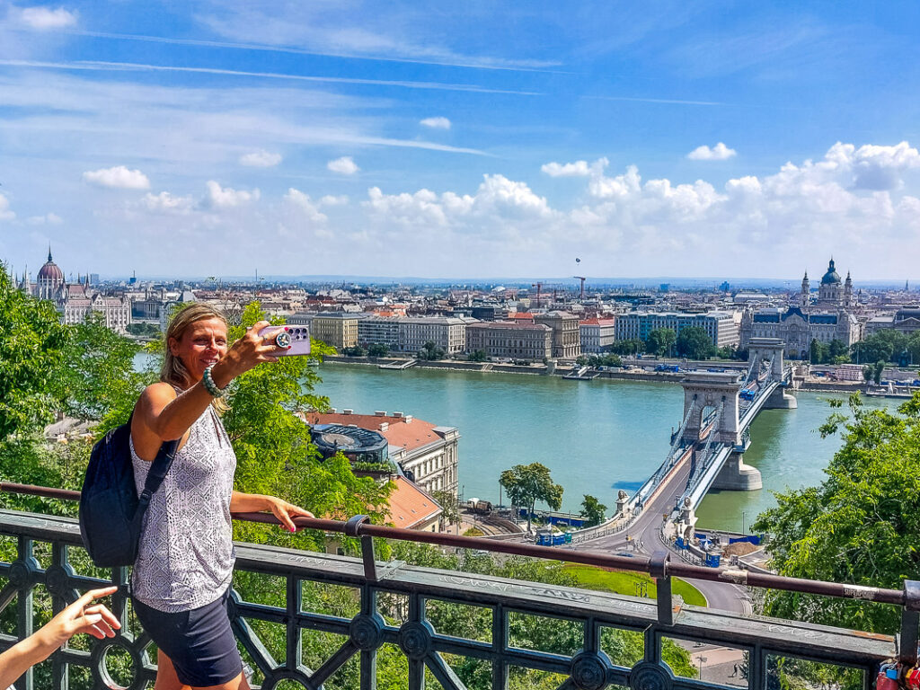 Lady taking a photo of a city and river