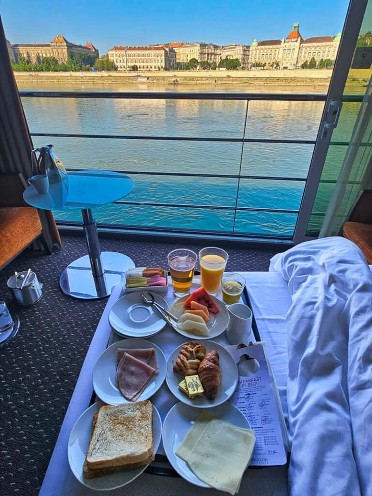 Tray of breakfast food on a bed in a cruise ship