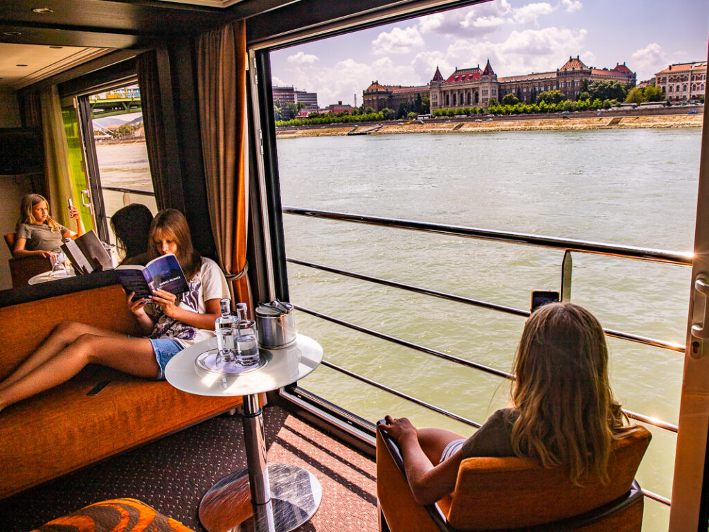 Two girls sitting in chairs on a river cruise with a view