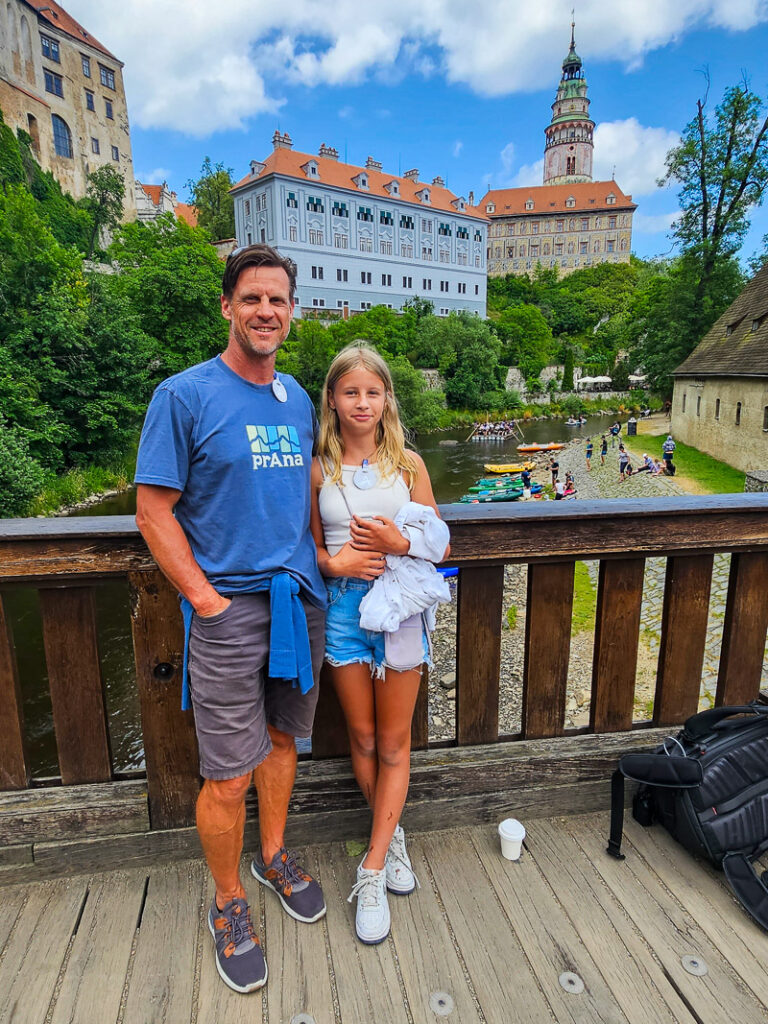Dad and daughter standing on a bridge with a castle in the background