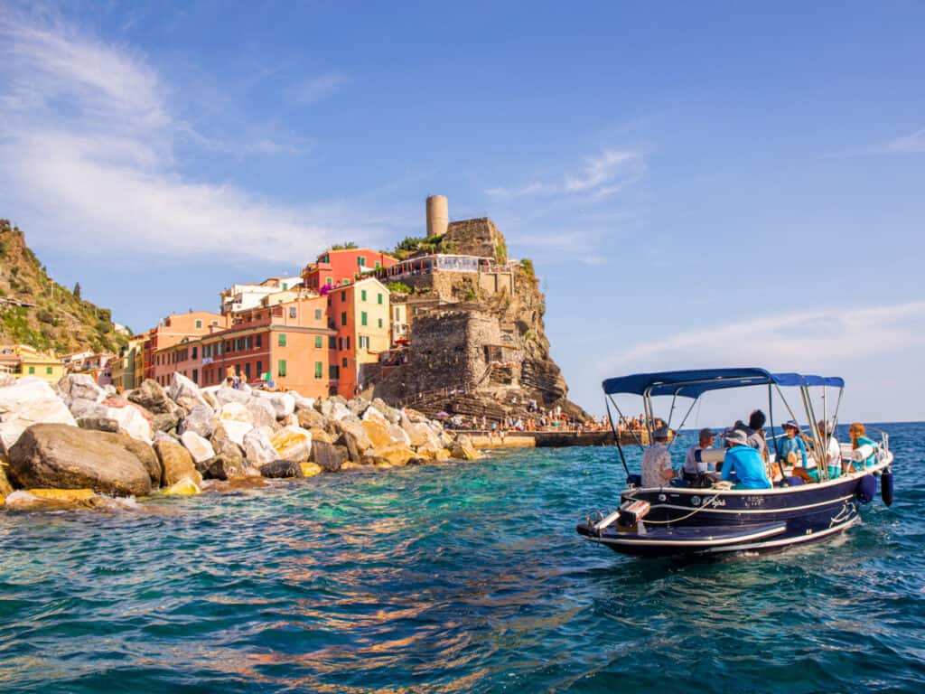 boat near shore with colored buldings of vernazza in background
