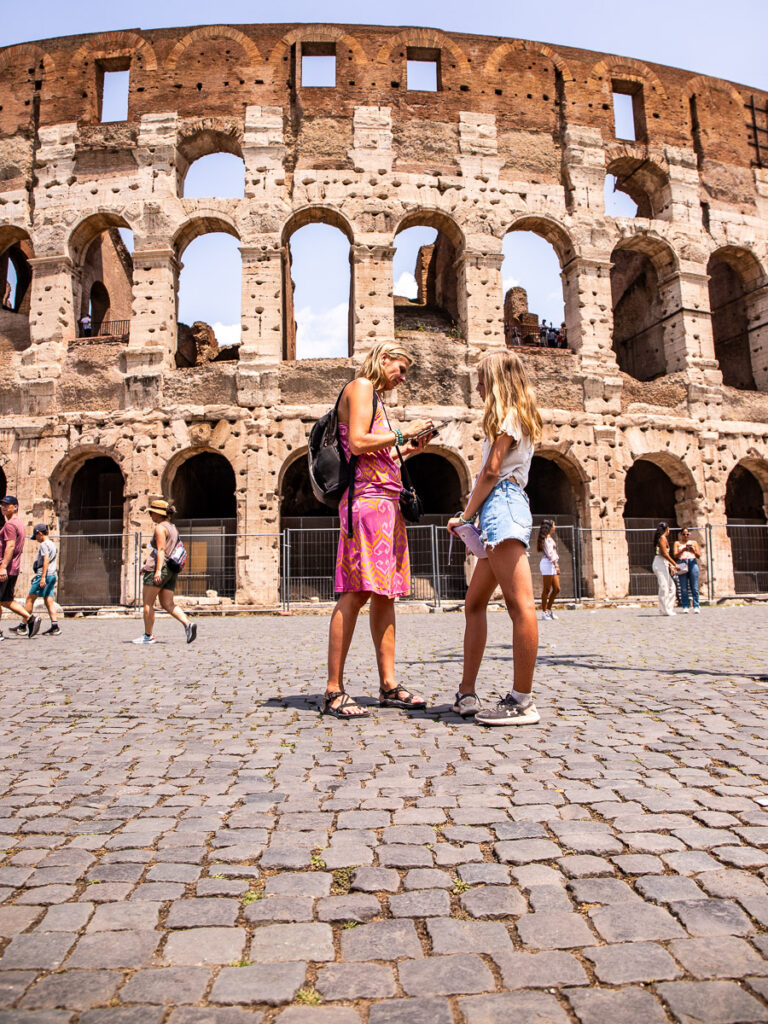 mom and girl standing outside colosseum in rome