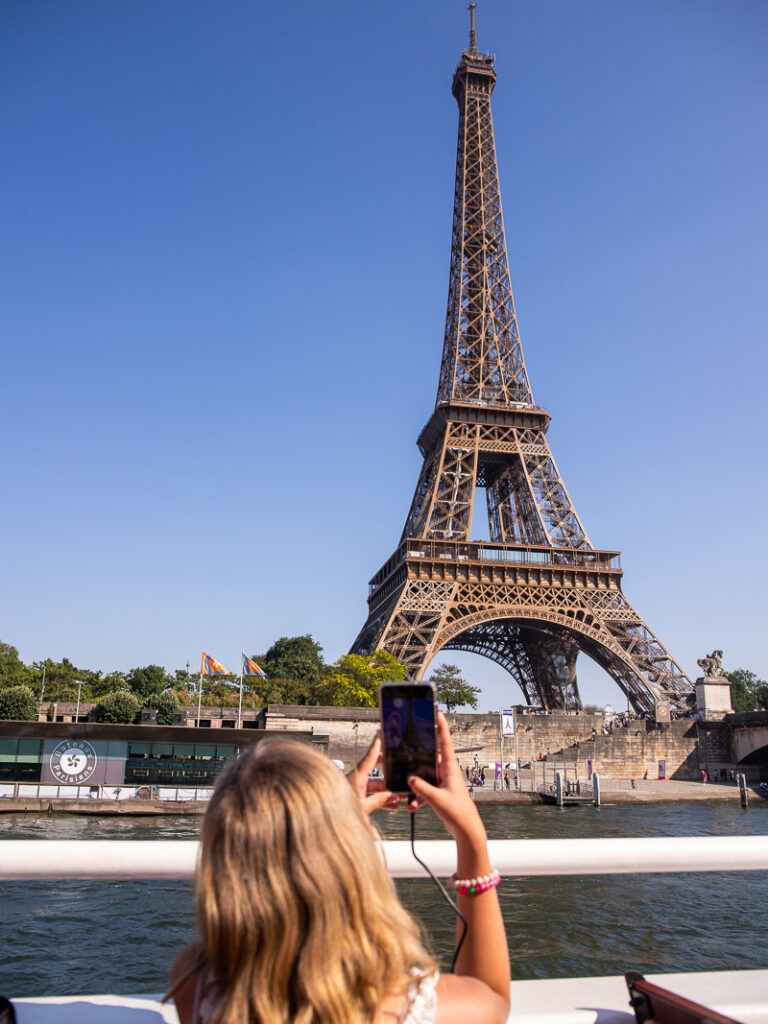 Young girl taking a photo of the Eiffel Tower in Paris