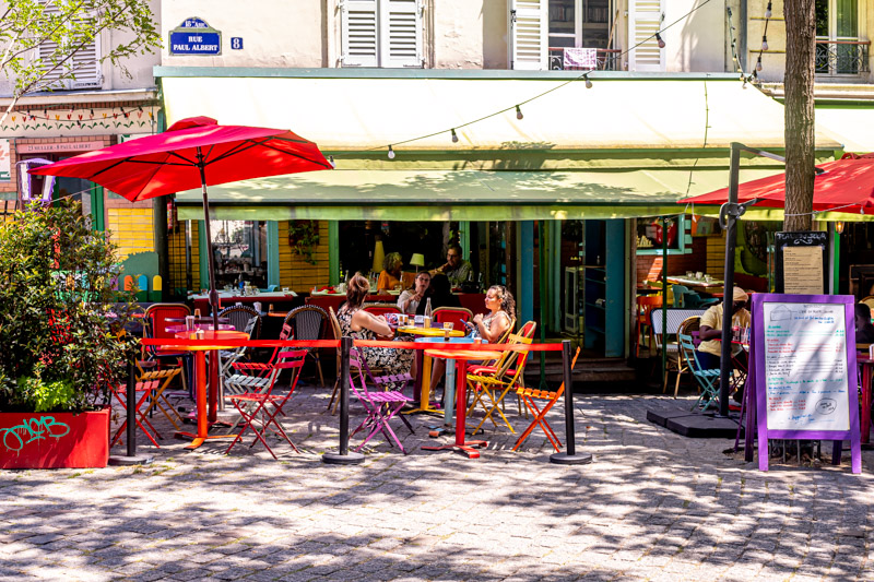 brightly colored tables on patio outside L'été en pente douce