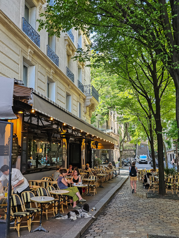 people sitting outside cafe in montmartre
