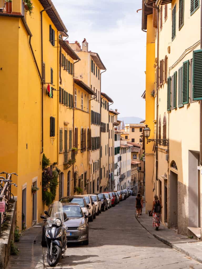 narrow street with colorful buildings on either side in oltrarno
