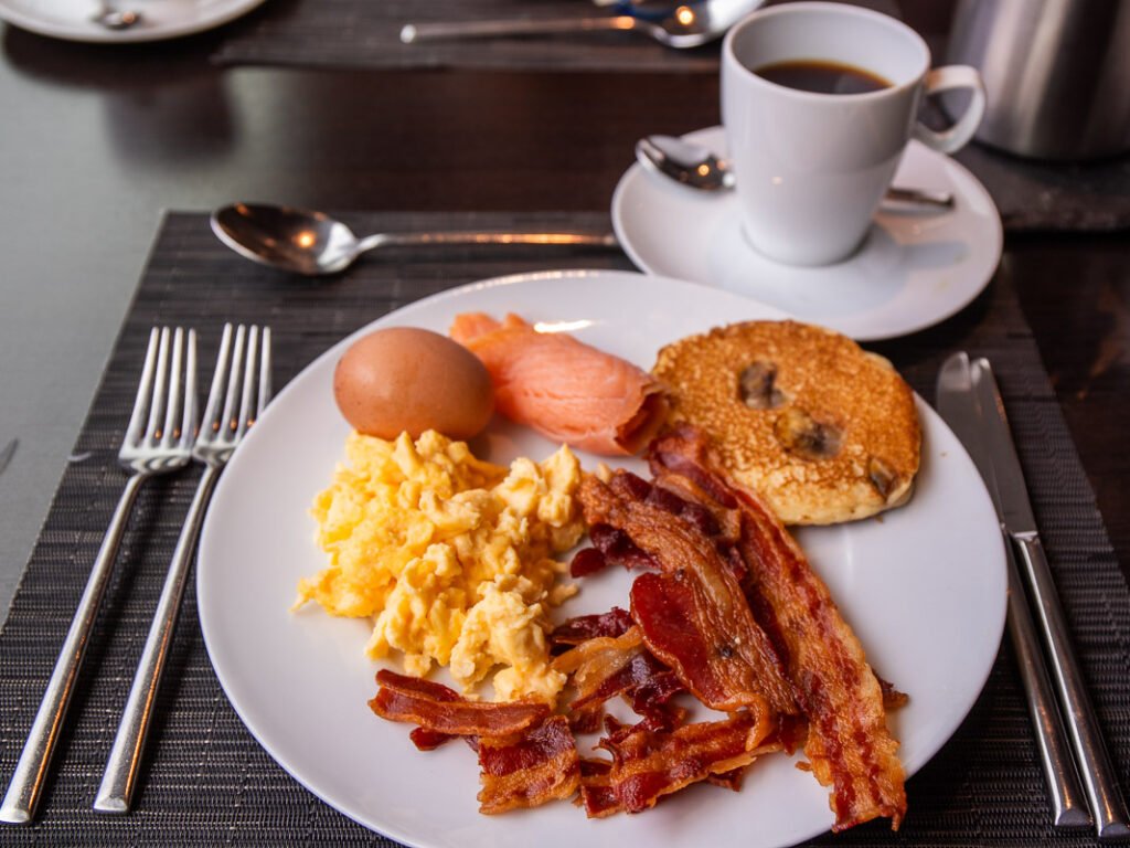 Bacon and eggs and coffee on a plate