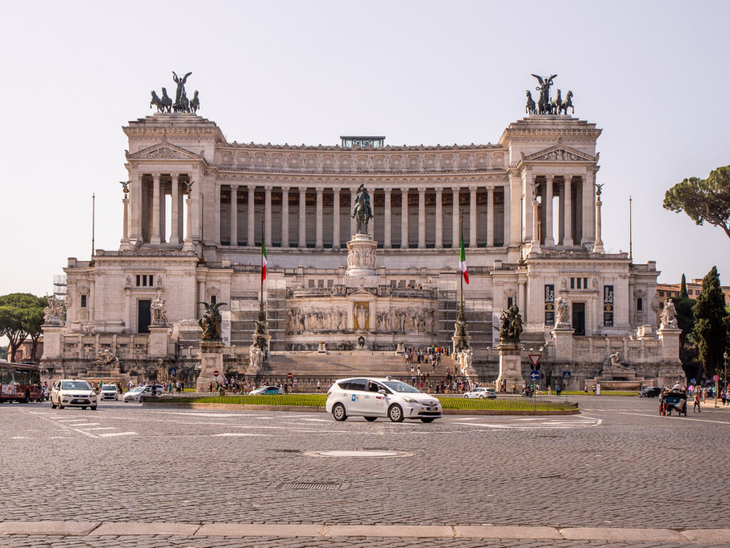 Car driving past a monument in Rome